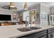 Close-up of the kitchen island featuring a stainless steel sink and faucet with an open living area in the background at 5182 Appenine E Loop, St Cloud, FL 34771