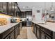 Beautiful kitchen featuring dark cabinetry, an island with barstool seating, and stainless steel appliances at 5182 Appenine E Loop, St Cloud, FL 34771