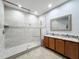 Modern bathroom featuring a large shower with glass enclosure, tiled walls and floors, and double sink vanity at 5431 Lochdale Dr, Orlando, FL 32818