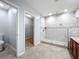 Spacious bathroom featuring a modern shower with glass enclosure, tiled walls, and a view to the walk-in closet at 5431 Lochdale Dr, Orlando, FL 32818