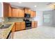 Well-equipped kitchen featuring granite counters, stainless appliances, wood cabinets, and tile flooring at 5431 Lochdale Dr, Orlando, FL 32818