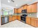 Stylish kitchen with stainless steel appliances, granite countertops, wood cabinets, and tiled floors at 5431 Lochdale Dr, Orlando, FL 32818