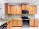 Modern kitchen featuring wood cabinets, granite countertops, stainless steel appliances, and tile backsplash at 5431 Lochdale Dr, Orlando, FL 32818
