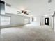 Large living room with neutral carpet, ceiling fan, and view of the front door and kitchen area at 5431 Lochdale Dr, Orlando, FL 32818