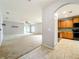 Open-concept living area with carpet flooring, neutral walls, and an archway to the kitchen for easy access at 5431 Lochdale Dr, Orlando, FL 32818