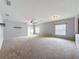 Open living room featuring a ceiling fan, neutral carpeting, and natural light from the windows at 5431 Lochdale Dr, Orlando, FL 32818