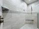 Close-up of modern shower featuring tiled walls, a built-in seat, and modern fixtures at 5431 Lochdale Dr, Orlando, FL 32818
