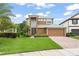 Charming two-story home features a well-manicured lawn, brick driveway, and attached two-car garage at 600 Egret Place Dr, Winter Garden, FL 34787
