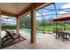 Screened-in outdoor pool area with stone pavers, lounge chairs, and an outdoor dining table with umbrella at 600 Egret Place Dr, Winter Garden, FL 34787