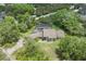 Aerial view of a home with a screened in pool, mature trees, and a long concrete driveway at 8735 Rancho Ct, Orlando, FL 32836