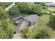 Aerial view of the home's exterior with mature trees and screened pool at 8735 Rancho Ct, Orlando, FL 32836