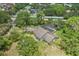 Aerial view of a home with a screened in pool surrounded by mature trees and lush landscaping at 8735 Rancho Ct, Orlando, FL 32836