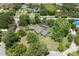 Aerial view of a home with a screened in pool surrounded by mature trees and lush landscaping at 8735 Rancho Ct, Orlando, FL 32836
