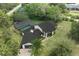 New rendering of home's exterior with dark roof and stone siding, with aerial view and pool at 8735 Rancho Ct, Orlando, FL 32836