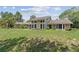 Exterior of home featuring stone and siding details on large lot with mature trees at 8735 Rancho Ct, Orlando, FL 32836