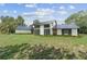Modern home showcasing a well-manicured lawn, textured white exterior, and sleek black accents at 8735 Rancho Ct, Orlando, FL 32836