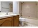Bathroom featuring vanity, tiled floor, bathtub with showerhead and surround tile, and white toilet at 9108 N Bay Boulevard, Orlando, FL 32819
