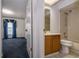 Bright bathroom featuring a vanity, tile flooring, and shower with tile surround, next to a blue-carpeted room at 9108 N Bay Boulevard, Orlando, FL 32819