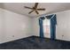 Comfortable carpeted bedroom with a ceiling fan and a window featuring an elegant blue valance at 9108 N Bay Boulevard, Orlando, FL 32819