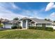 Inviting single-story home with blue paint, arched windows, and a well-kept front lawn at 9108 N Bay Boulevard, Orlando, FL 32819