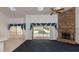 Spacious living room with a brick fireplace, skylights, and sliding glass doors leading to the pool area at 9108 N Bay Boulevard, Orlando, FL 32819
