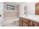 Bathroom featuring bathtub and shower combo, toilet, sink with mirror, and grab bars for accessibility at 1007 Glendale St, Orlando, FL 32807