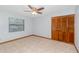 Light-filled bedroom boasts tile floors, a ceiling fan, and a large closet with paneled doors at 1007 Glendale St, Orlando, FL 32807