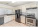 Traditional style kitchen with stainless steel appliances and white cabinetry and tile floors at 1007 Glendale St, Orlando, FL 32807
