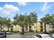 View of the condo building with parking lot and landscaping, under a sunny sky with scattered clouds at 1125 Lake Shadow Cir # 5109, Maitland, FL 32751