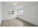Bright bedroom featuring gray wood-look floors and two windows providing natural light at 11540 Harbor Rd, Leesburg, FL 34788