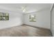Bright bedroom featuring wood-look floors, two windows, and ample natural light at 11540 Harbor Rd, Leesburg, FL 34788