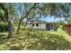 A cozy home exterior featuring an enclosed porch and a spacious, well-maintained backyard with mature trees at 11540 Harbor Rd, Leesburg, FL 34788