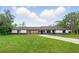 Charming single-story home with a long driveway, inviting curb appeal, and ample green space at 11540 Harbor Rd, Leesburg, FL 34788