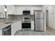 Modern kitchen featuring stainless steel appliances, gray backsplash, and granite countertops at 11540 Harbor Rd, Leesburg, FL 34788