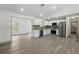 Open floor plan showcases new gray flooring and fresh white paint connecting the living room and kitchen at 11540 Harbor Rd, Leesburg, FL 34788