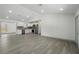 Spacious living room with new gray flooring and freshly painted white walls leads into the modern kitchen at 11540 Harbor Rd, Leesburg, FL 34788