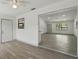 Open living space with new gray floors, fresh white paint, and seamless transition to the adjacent room at 11540 Harbor Rd, Leesburg, FL 34788