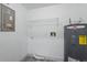 Functional utility room with shelving, connections, and a modern water heater unit at 11540 Harbor Rd, Leesburg, FL 34788