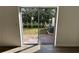 View of green backyard through sliding glass door with patio, ready for outdoor enjoyment at 1205 Southstation Pl # 208, Orlando, FL 32809
