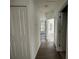 A bright hallway with wood floors has doors leading to bedrooms at 1205 Southstation Pl # 208, Orlando, FL 32809