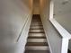 The staircase features wood-look steps and white railing at 1205 Southstation Pl # 208, Orlando, FL 32809