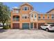 Three-story townhome with individual garages and inviting neutral color palette on a sunny day at 12414 Baleria Cv # 104, Orlando, FL 32837