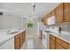 Well-lit kitchen with white appliances, tile flooring, wooden cabinets, and white countertops at 12414 Baleria Cv # 104, Orlando, FL 32837