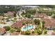 Aerial view of a community pool surrounded by lush landscaping and multiple buildings at 12414 Baleria Cv # 104, Orlando, FL 32837