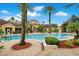 Beautiful community pool surrounded by tropical landscaping, palm trees, and lounge chairs at 12414 Baleria Cv # 104, Orlando, FL 32837