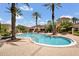 Beautiful community pool surrounded by palm trees and lounge chairs for relaxing at 12414 Baleria Cv # 104, Orlando, FL 32837