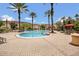 Community pool with lounge chairs surrounded by well-maintained landscaping and tropical palm trees at 12414 Baleria Cv # 104, Orlando, FL 32837