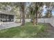 Backyard featuring lush lawn, playset, mature trees, fenced perimeter, creating a private oasis at 1307 Pup Fish Ln, Deland, FL 32724