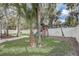 Spacious backyard features a playset, lush lawn, and mature trees, creating a serene outdoor space at 1307 Pup Fish Ln, Deland, FL 32724