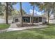 View of backyard featuring screened in porch, bench, and a concrete patio surrounded by lush green grass at 1307 Pup Fish Ln, Deland, FL 32724